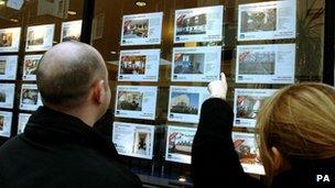 Couple standing outside estate agents