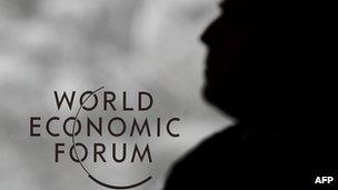 A guard stands next to a logo of the World Economic Forum