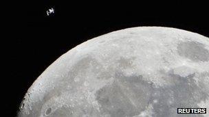 International Space Station is seen as a small object in the upper left of this image of the moon from Houston, Texas, 4 January 2012