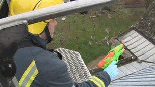 Firefighters use water pistols to spray the church roof