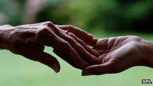 Young person touching hand of older person