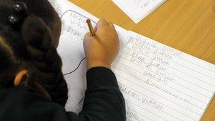 Primary school pupil writing in an exercise book