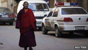 An ethnic Tibetan monk walks past a police station in Danba, Sichuan province on 26 January 2012