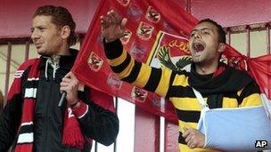 An injured fan (right) and his friend chant anti-military slogans in front of the al-Ahly club in Cairo. Photo: 2 February 2012