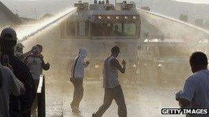 Water cannon being used on a group