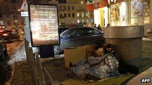 Homeless people sit by an air vent in Kiev, Ukraine (31 Jan 2012)