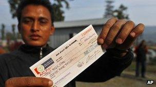 A former Maoist rebel displays a check presented by the government at Shaktikhor Maoist Camp in Chitwan, about 100 miles (160 km) south of the capital Kathmandu, Nepal, Friday, Feb. 3, 2012.