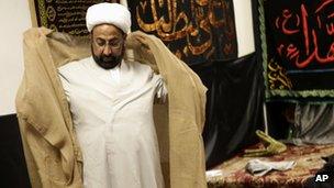 Imam Malik Sakhawat Hussain puts on formal garb for an interview at the Al-Mahdi Foundation in New York, 1 February 2012