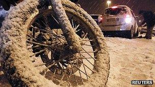 Snow covers bikes and cars in Rome. 3 Feb 2012