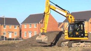 A mechanical digger begins to work on a building site