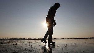 A man ice skates on the frozen fens in Welney, Norfolk