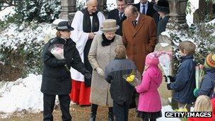 The Queen and the Duke of Edinburgh receiving flowers from children