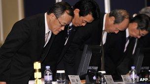 Olympus president Shuichi Takayama and company executives bow their heads