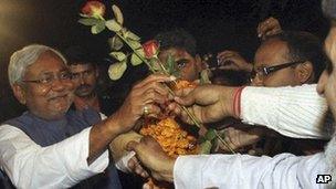 Nitish Kumar accepts flowers from supporters after his election victory in Patna, on 24 Nov 2010