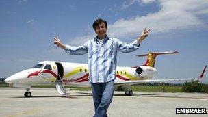 Jackie Chan in front of his Embraer jet