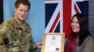 Prince Harry presents Jacqui Thompson with an award at RAF Honington