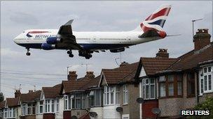 A plane flies over homes in west London