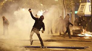 A protester throws an object at police in Athens. Photo: 12 February 2012