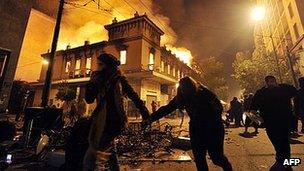 Greeks run past burning building in Athens, 12 Feb 12