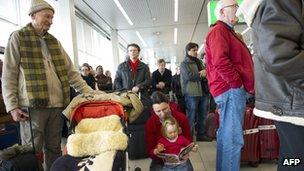 Passengers wait at Schiphol airport