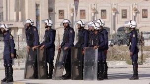 A line of riot police in front of razor wire near a shopping mall and cinema in Manama, Bahrain on 14 February 2012