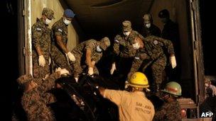 Soldiers help remove the corpses from the scene at the prison in Comayagua