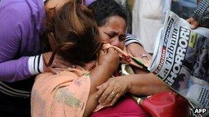 Women cry while they wait to recover the remains of a relative, killed during Comayagua prison fire, at the Forensic Department in Tegucigalpa on 16 February 2012