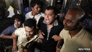 Supporters of former Maldives president Mohamed Nasheed shout slogans in front of police officers during a protest in Male on 12 February