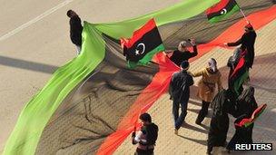 Libyans wave Kingdom of Libya flags as they celebrate the first anniversary of the uprising that toppled Muammar Gaddafi