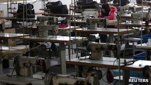 A worker works while surrounded by unmanned sewing machines at the production line of a bag factory in Yiwu, Zhejiang province (file photo)