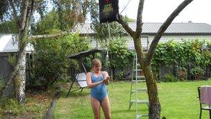 Girl in swimsuit under garden shower. Photo: Graham Crook