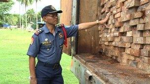 Police Superintendent Enrique Chacaol with his seizure of mahogany