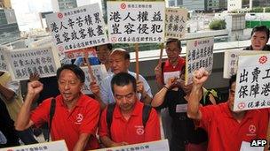 Protesters hold banners against the ruling allowing domestic workers to apply for residency