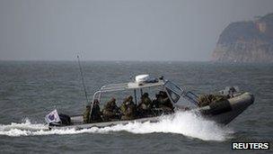 South Korean naval personnel go on a boat patrol near Yeonpyeongdo island as South Korean marines conduct live fire exercise on the island in Ongjin county, off Incheon, west of Seoul February 20, 2012