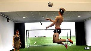 An athlete with sensors stuck to his body prepares to play football in the new Ajax miCoach Performance Centre in Amsterdam