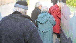 Elderly people getting on a minibus