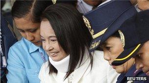 Former Philippine President Gloria Macapagal Arroyo escorted by policemen after attending her court arraignment in Pasay city, Metro Manila 23 February, 2012