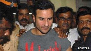 Bollywood actor Saif Ali Khan is escorted by police at a police station in Mumbai on 22 February 2012