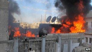 A handout picture released by activist group the Local Co-ordination Committees in Syria (LCC Syria) on 22 February 2012 shows fire on the roof of a building in the Baba Amr neighbourhood of the flashpoint city of Homs, allegedly during the bombardment of the city