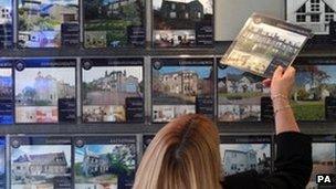 Woman looking at houses in estate agents