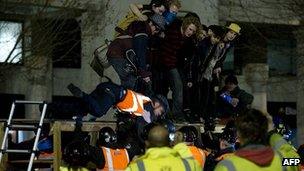 A bailiff is pulled from a makeshift barricade at the Occupy protest camp