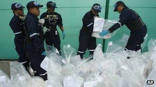 City employees organize seized bags of cocaine to be burned at a police base in Lima, Peru, 7 February 2012.