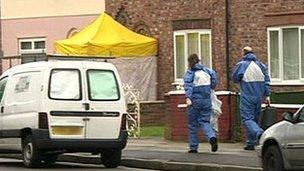 Forensic officers approach the house in Norris Green