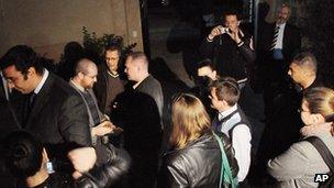 Workers from the National Democratic Institute NGO wait outside as officials raid their office, 29 December 2011