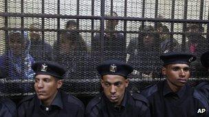 Egyptian policemen sit in front of Egyptian employees of several pro-democracy groups in Cairo, Egypt. 26 February 2012