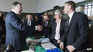 Iceland's ex-PM Geir Haarde shakes hands with Sigridur Fridjonsdottir, parliament prosecutor with her assistant Helgi Magnae's Gunnarsson in Reykjavik