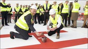 Hospital trust chief executive Andrew Morris and Adam Wells, construction director, finish painting the giant 'H' on the new helipad at Frimley Park Hospital