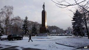 A man walks past a statue in Chisinau, Moldova (March 6, 2012)