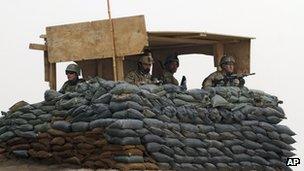 US and Afghan soldiers man a watch-tower at their base in Panjwai, Kandahar, 11 March