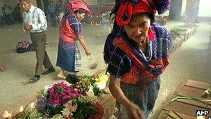 A Maya woman burns incense over some of the coffins of massacred victims before their funeral April 2002 in Zacualpa